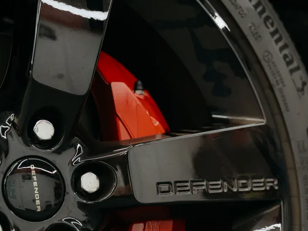 Red painted brake caliper behind gloss black wheel — Hussle Customz Los Angeles
