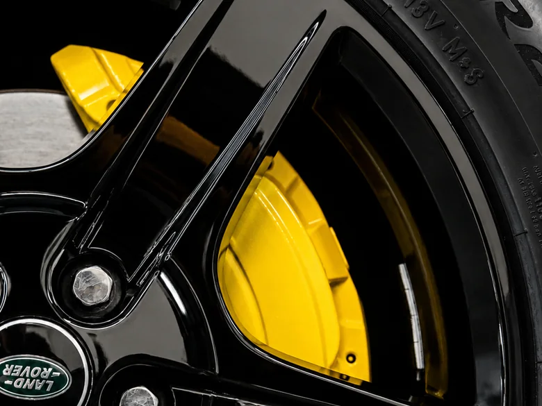 Yellow brake caliper behind gloss black wheel — professional caliper painting Los Angeles